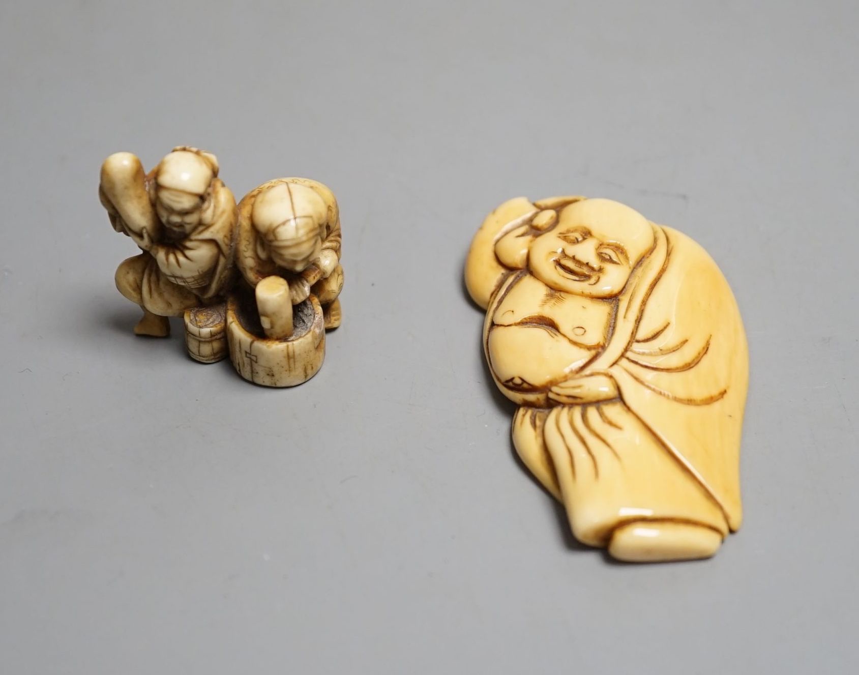 A Japanese Edo period ivory netsuke of Hotei and a Meiji period ivory netsuke of Daikoku and Ebisu, largest 6.5 cms high.